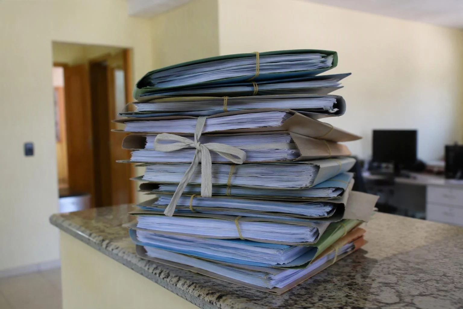 Pastas de documentação empilhadas sobre o balcão do escritório
